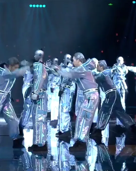 Reel da Eixo: robôs humanoides dançando com bailarinos num palco